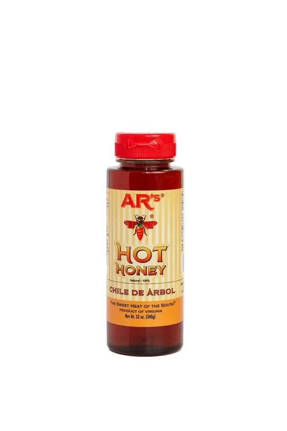 A bottle of AR's Hot Honey (Chile de Arbol) featuring a red cap and a yellow label with a red bee logo, set against a plain white background.