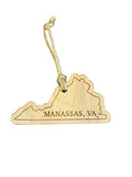 A wooden ornament in the shape of Virginia with 'MANASSAS, VA' engraved on it, hanging on a granite surface.