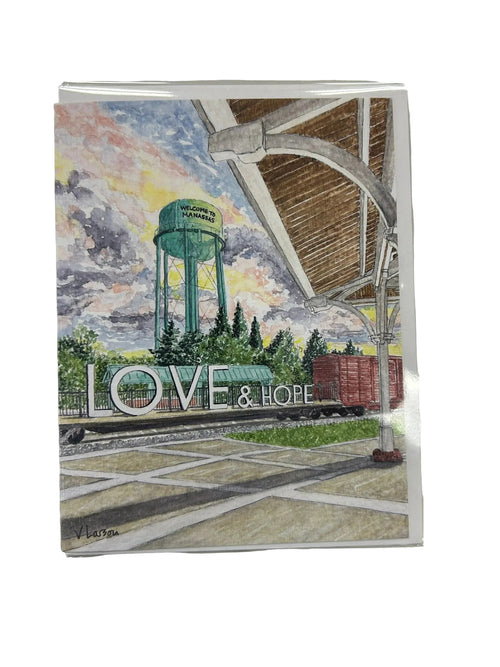 Artistic depiction of a water tower with 'LOVE & HOPE' text, framed in clear plastic.
