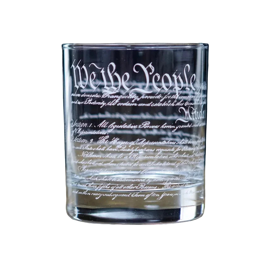 Clear glass tumbler with engraved text "We the People" on white background